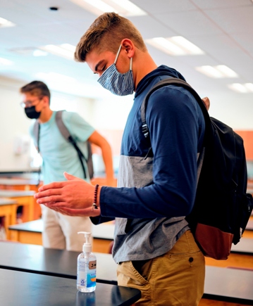 Student using hand sanitizer