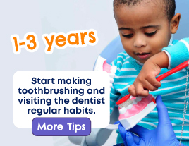 A young boy using a toy toothbrush to clean a set of toy teeth 