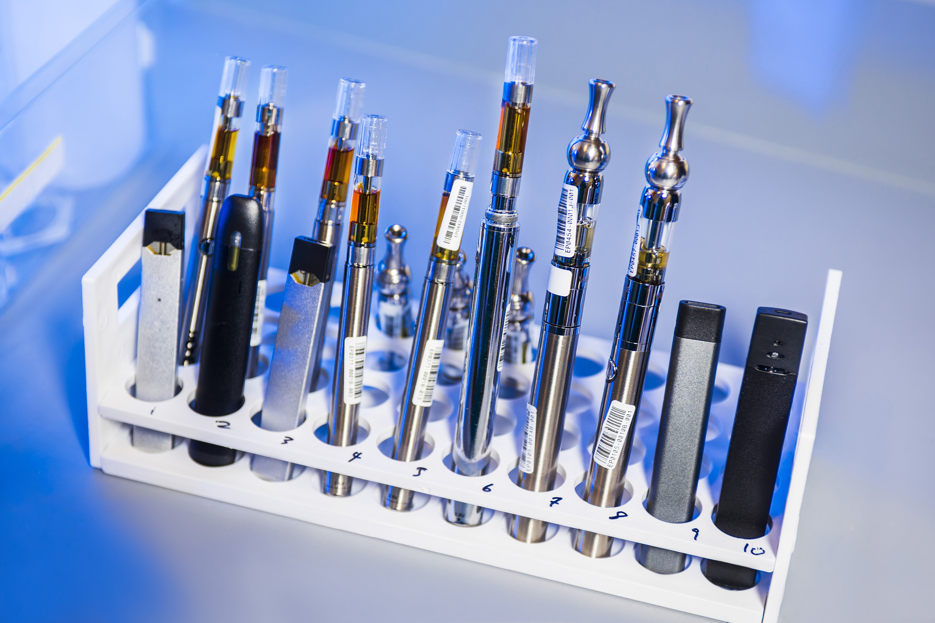 A test tube rack that displays various types of vapes